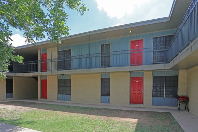A Hamilton Place courtyard elevation with red apartment doors along both stories.